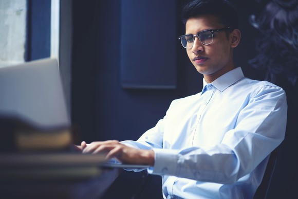 Man typing on a laptop.