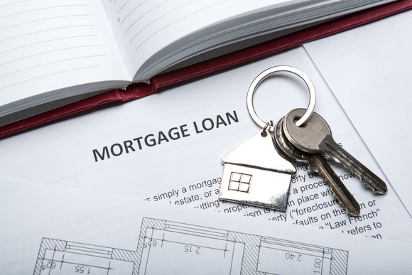 Set of house keys on top of a document headlined mortgage loan.