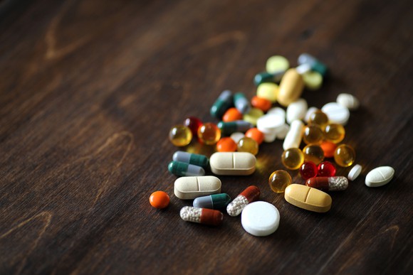 Pills of many colors on a table.