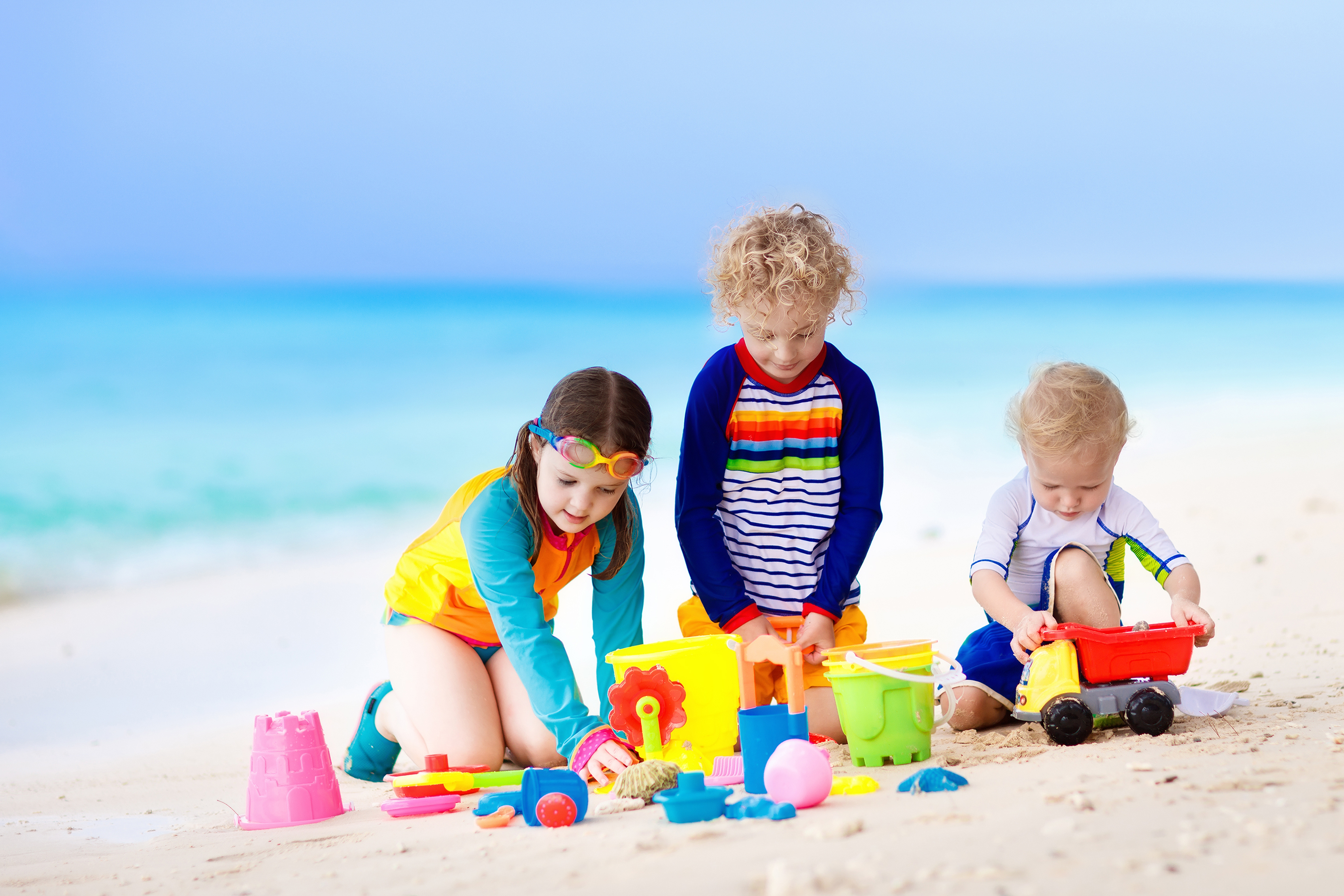 Kids playing with toys at the beach.