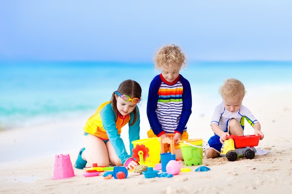 Kids playing with toys at the beach.
