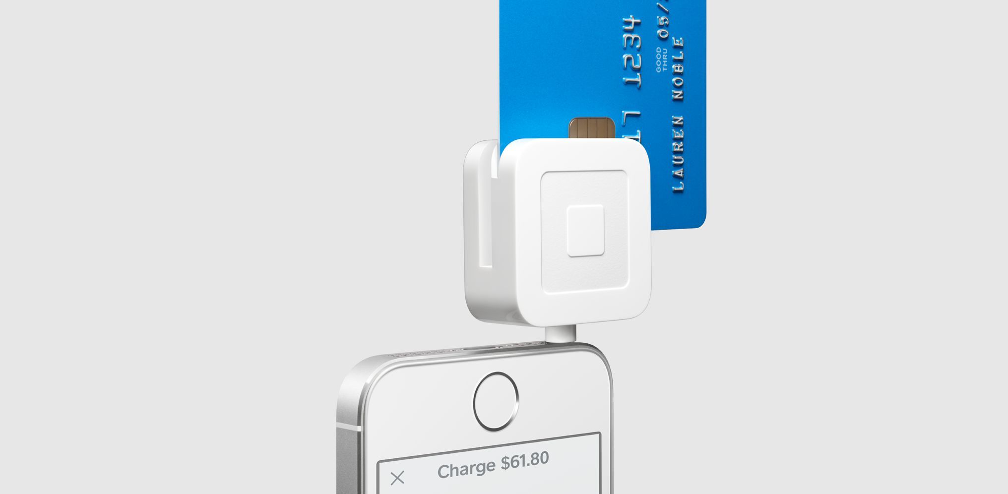 Square's card reader attached to an iPhone capturing a credit card.