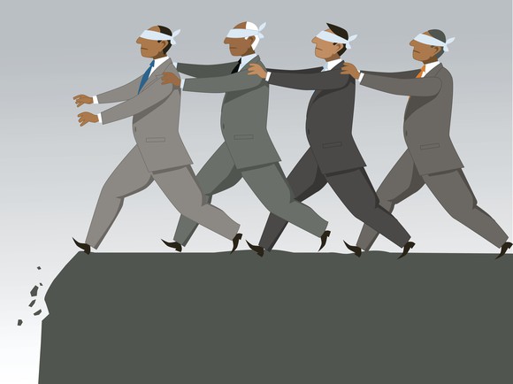 Group of blindfolded businessmen following each other in single file to the edge of a cliff.