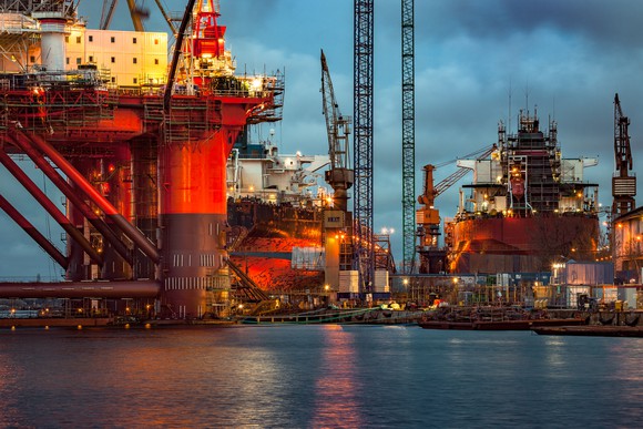 Multiple offshore rigs in a dockyard.