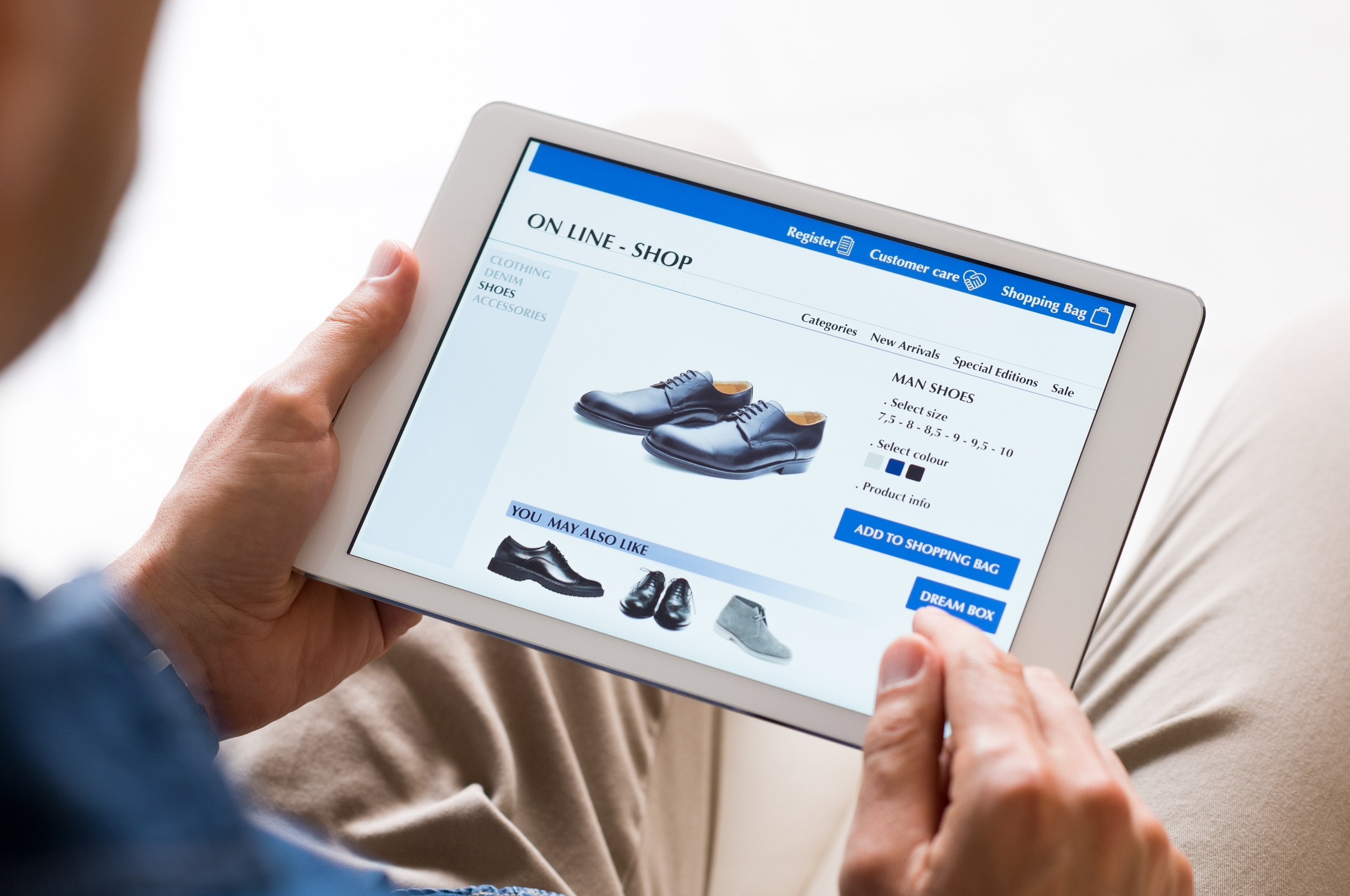 A man buying shoes online on a tablet.