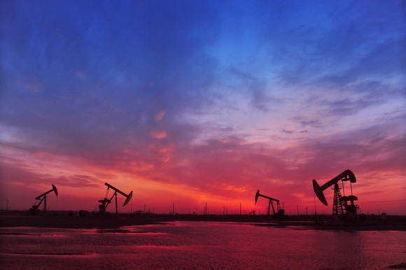 Oil pumps with a red and blue sky above.