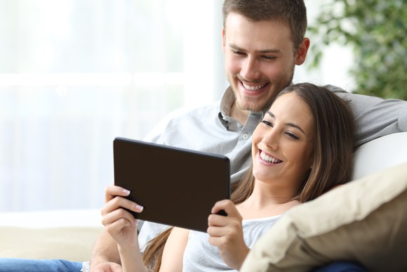 Smiling couple looks at a tablet