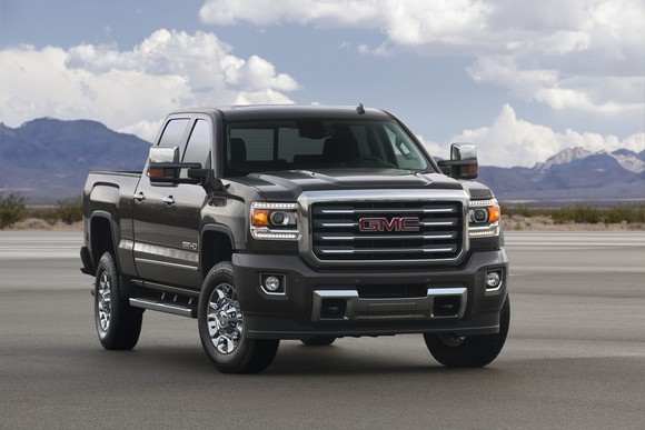 GMC truck sitting on an empty patch of concrete in a dry landscape.