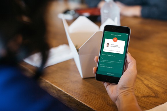 A woman sends money with the PayPal app