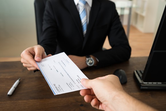 Businessperson being handed a check.