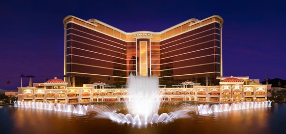 Wynn Palace casino resort in Macau, with lit-up fountains in front of the hotel.