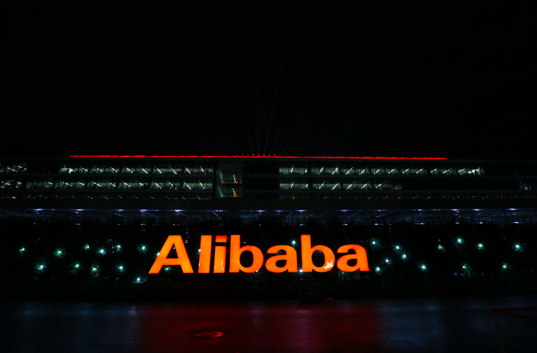 An orange lit up sign reads "Alibaba" in front of the company's headquarters