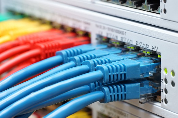 An enterprise-grade Ethernet switch, populated with bundles of colorful cables.