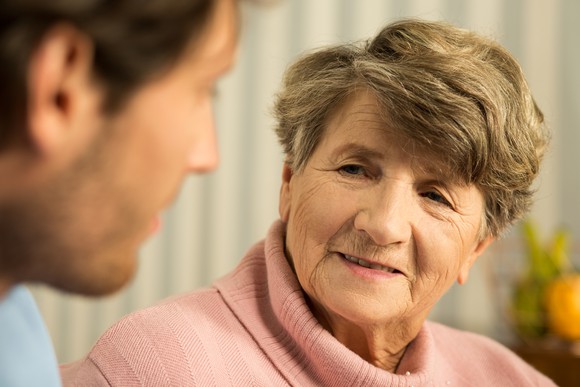 Senior woman talking to younger man