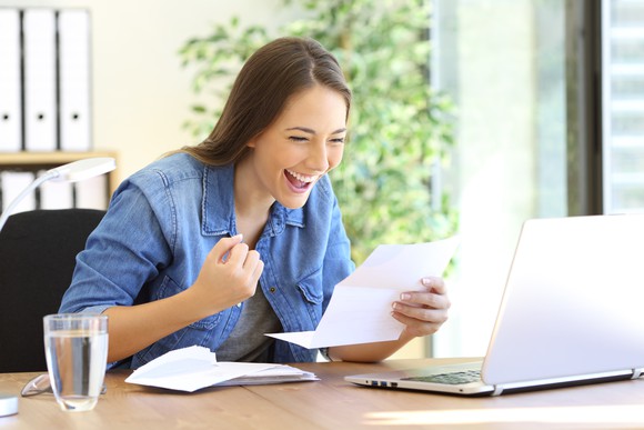 Woman looking at a piece of paper with a happy expression on her face