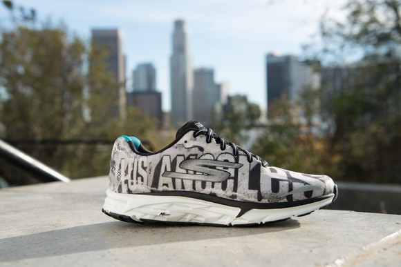 A Skechers shoe with distant buildings behind it