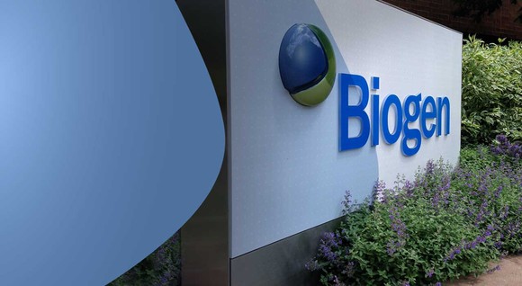 Sign with Biogen logo on it with flowers in front.
