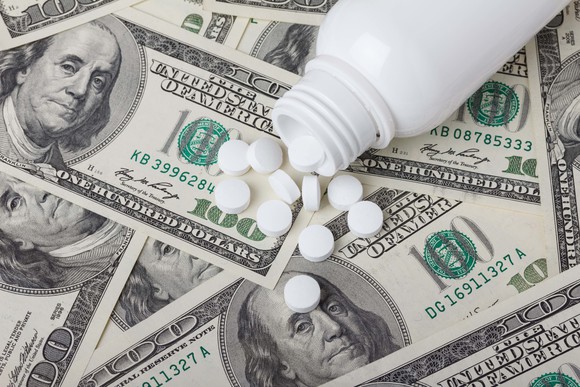 Pills spilled on top of hundred dollar bills