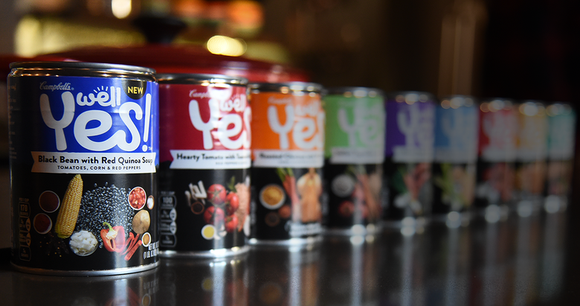 Cans of Campbell's "Well Yes!" soups lined up on table.