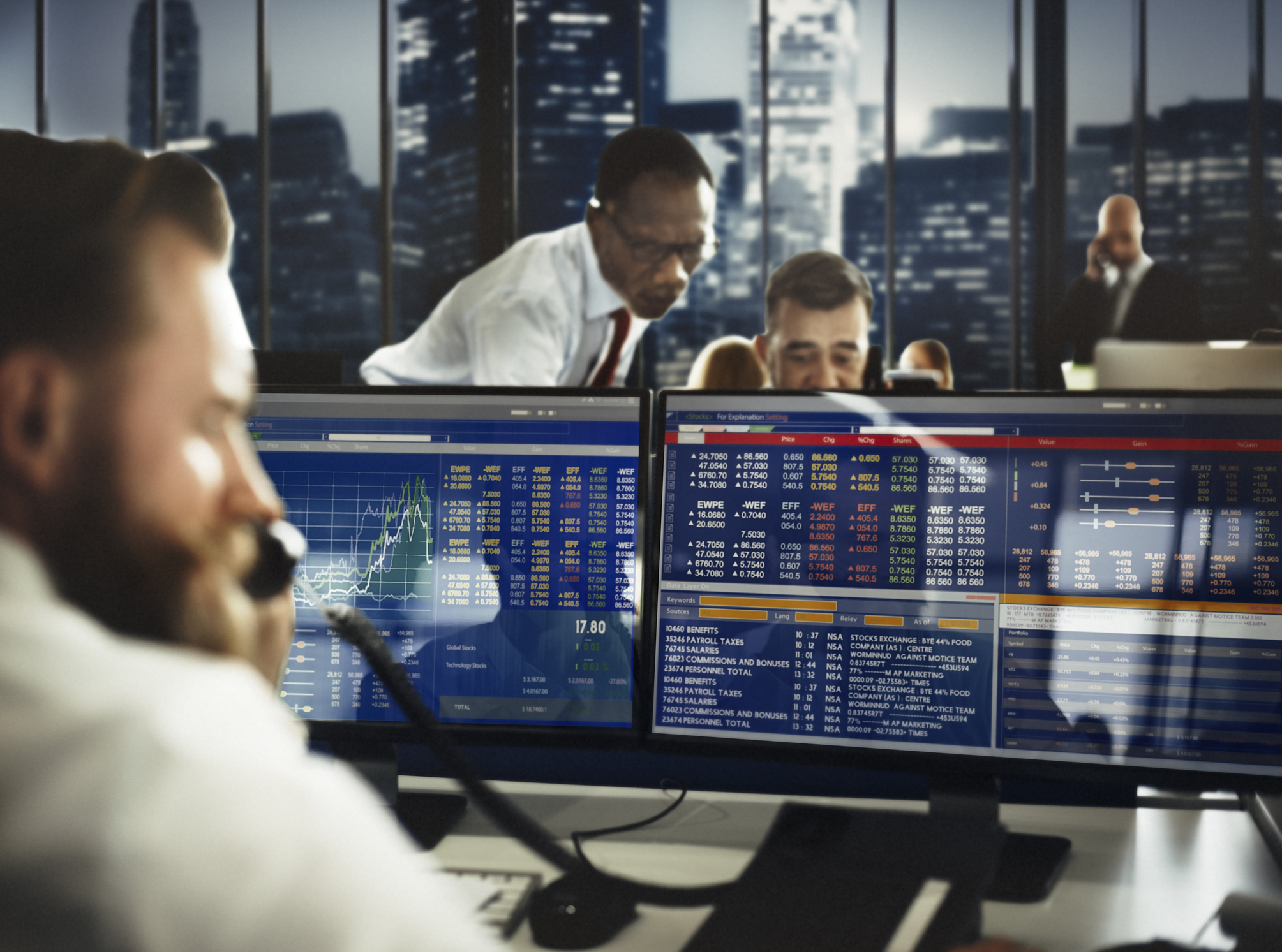 Stock traders looking at computer screens