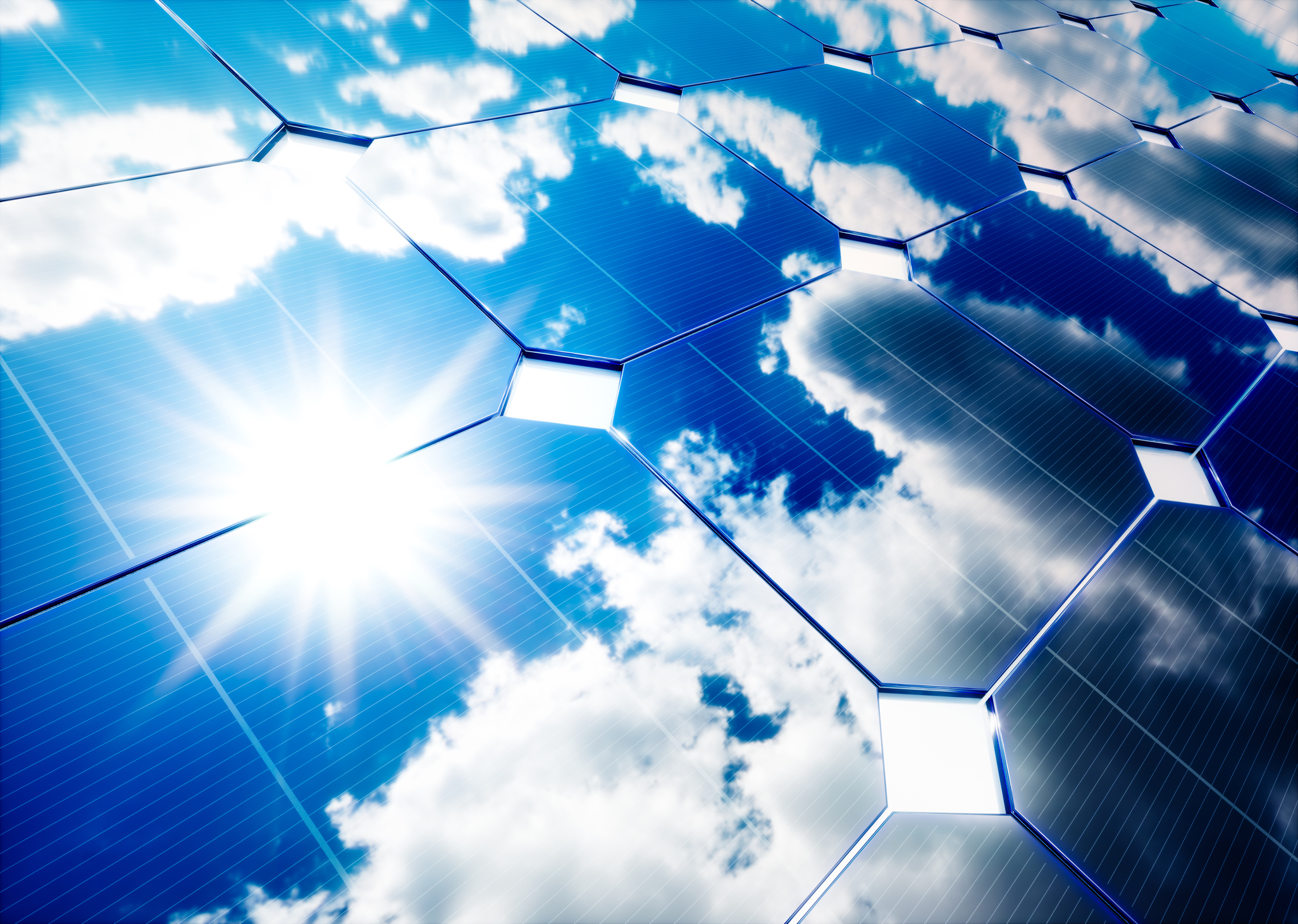 Solar panel reflecting the sun and blue skies with patchy clouds.