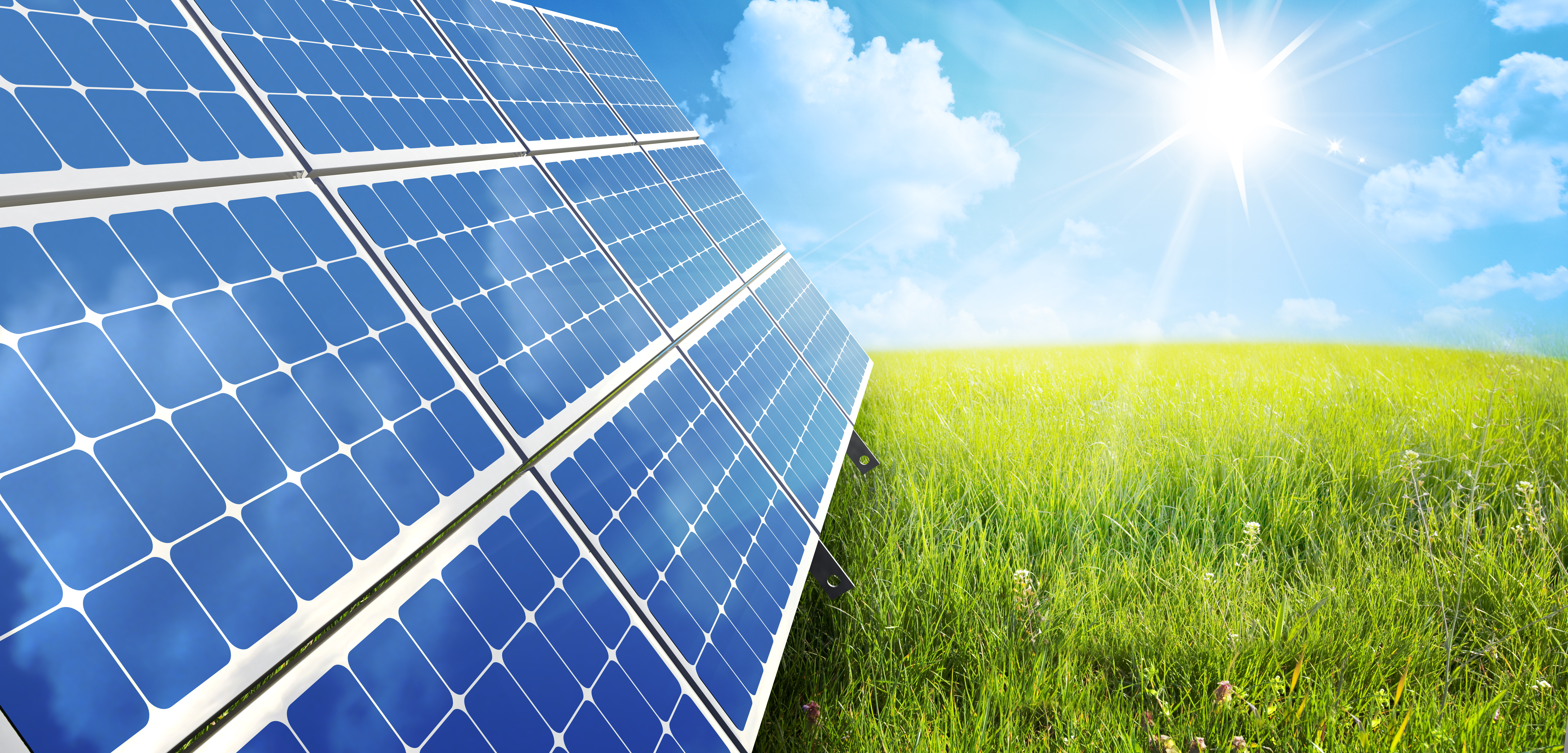 Small solar array on the grass with the sun in the background. 