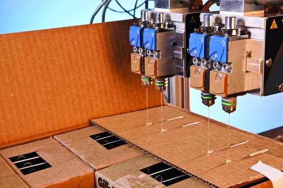 Nordson equipment dispensing glue onto cardboard