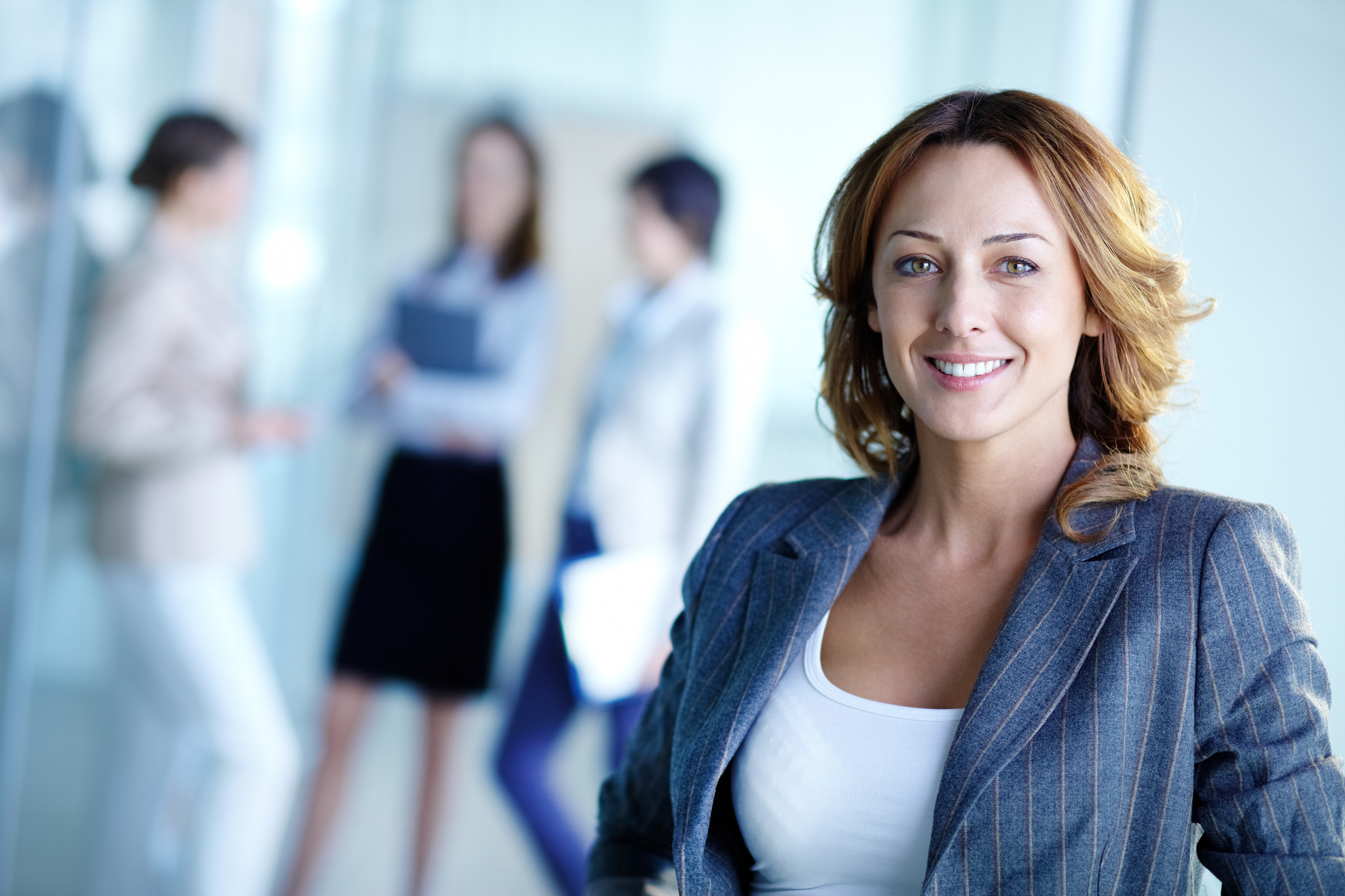 Smiling businesswoman with three other people in the background