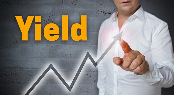 The word yield written above an upward sloping chart while a man points to the arrow.