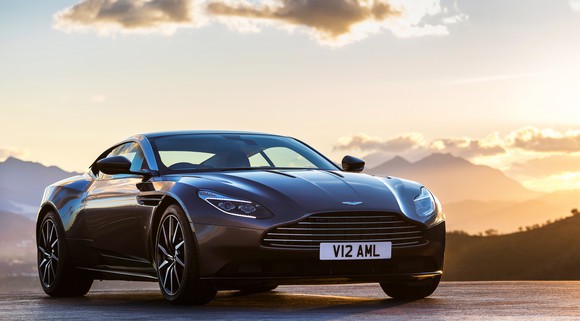 A dark gray Aston Martin DB11, a luxury sports coupe.