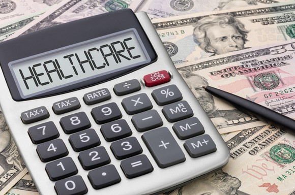 Calculator displaying "healthcare" on screen on top of cash