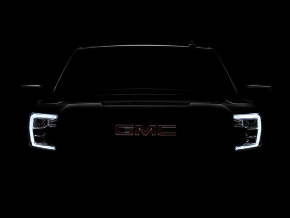 A darkened photo of the front end of the new GMC Sierra.