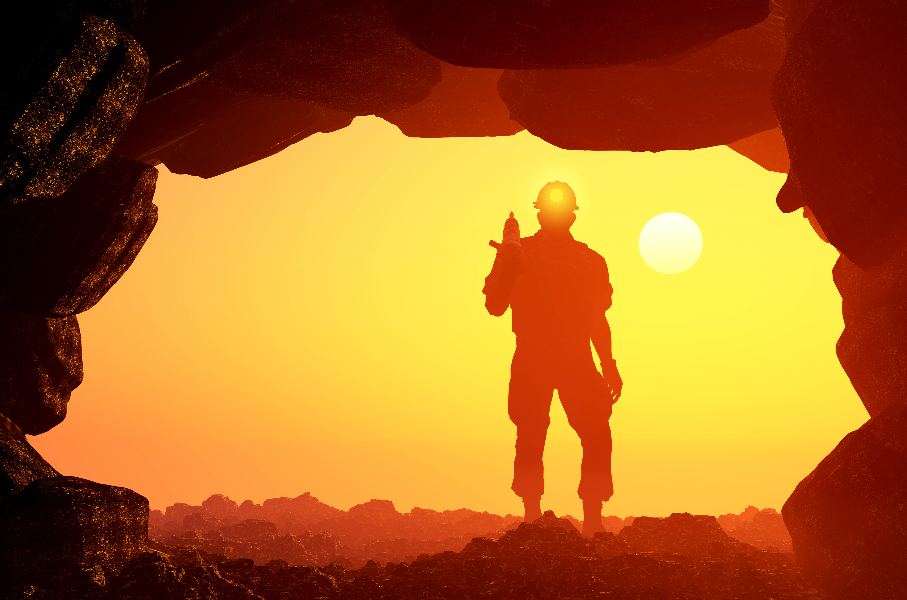A miner standing with the sun behind him at the mouth of a mine
