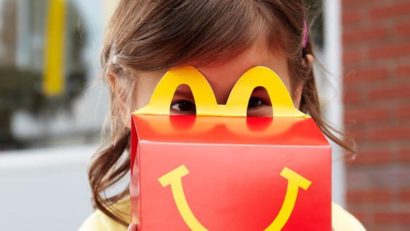 Child behind McDonald's Happy Meal box.