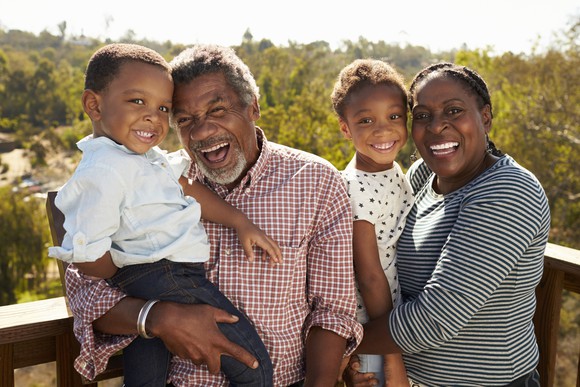 Mature couple standing on deck with their grandchildren