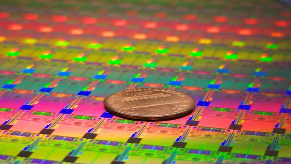 A wafer of Intel processors with a penny on top.