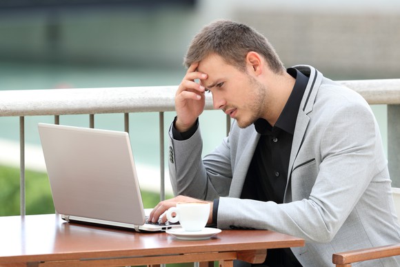 Young businessman in deep thought over his laptop.