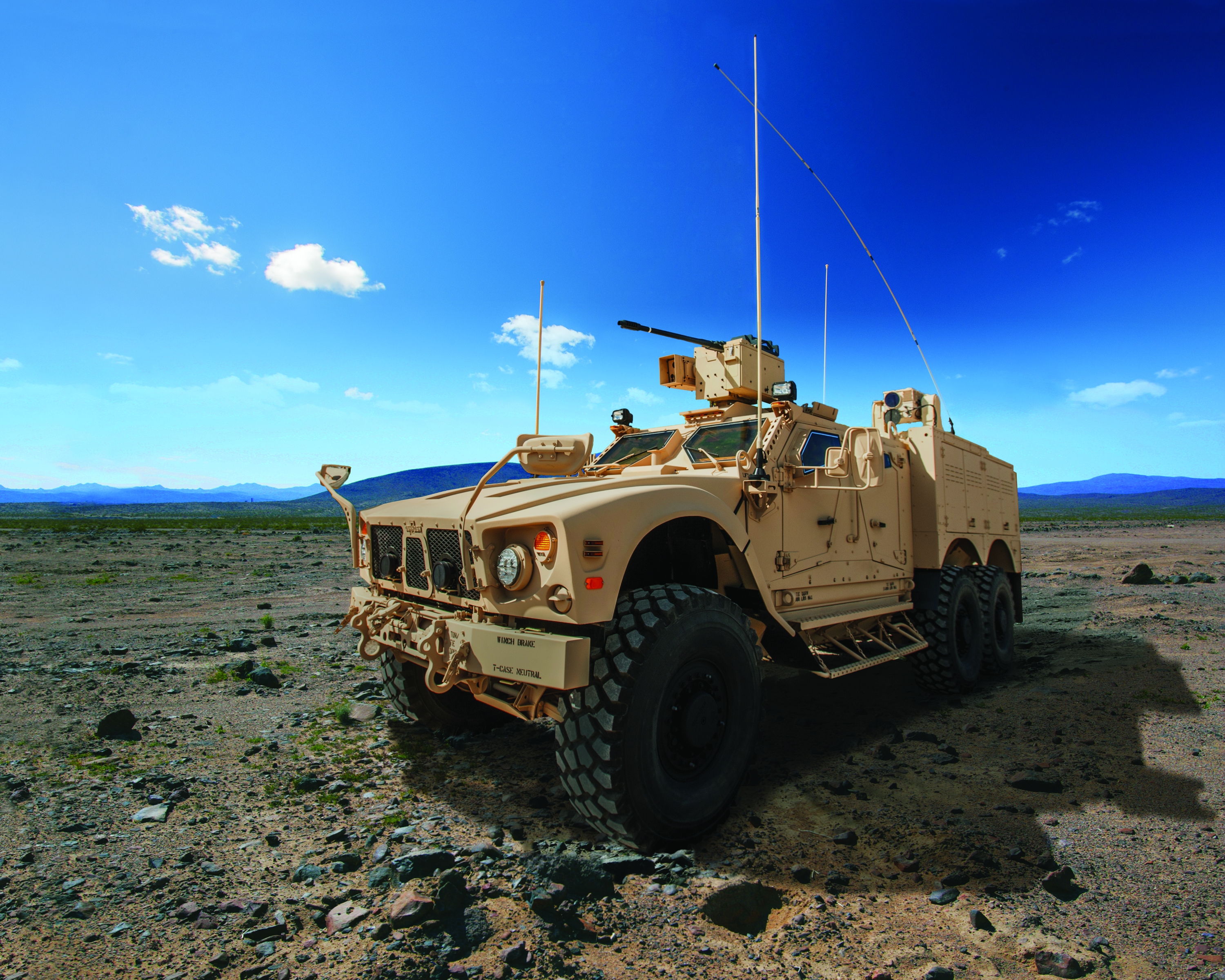 The Oshkosh Corp.'s M-ATV 6x6 on dirt under a blue sky
