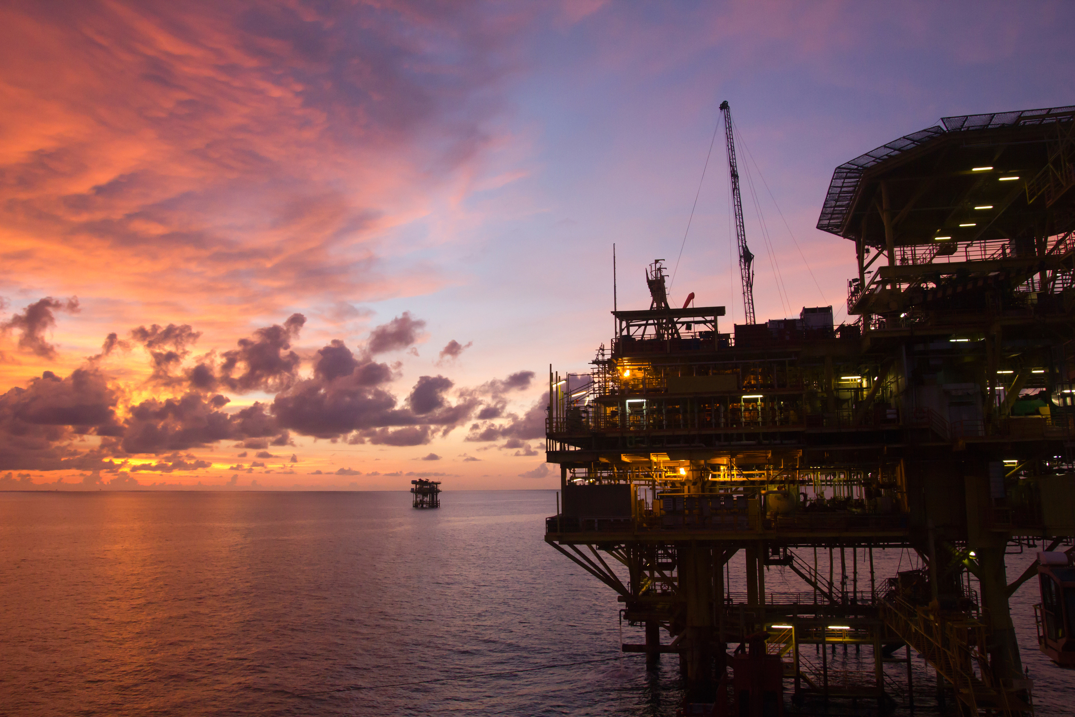 Silhouette of an offshore oil platform at sunset