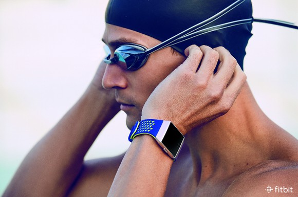 Man wearing swim cap, goggles, and Fitbit Ionic