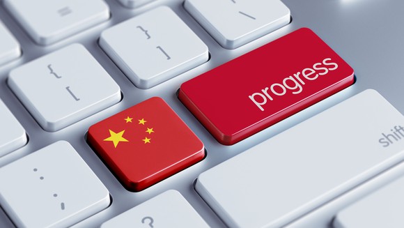 A Chinese flag and the word progress on a keyboard