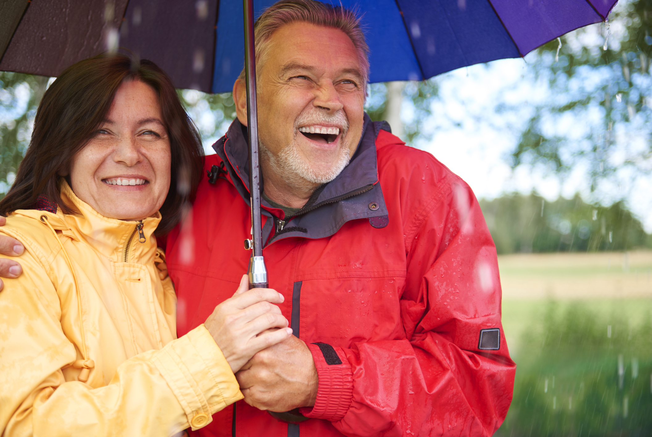 Smiling older couple under an umbrella