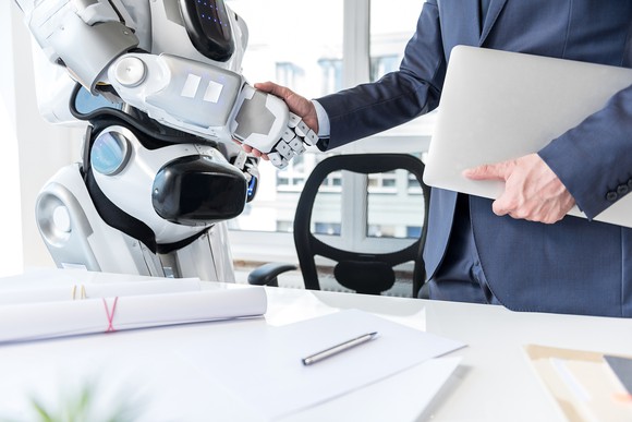 A robot and a human shake hands.