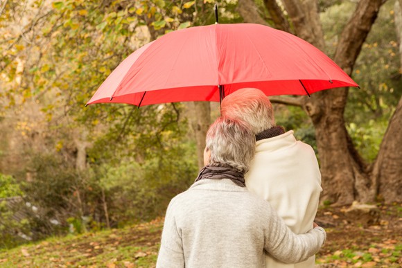 Senior couple outdoors under an umbrella