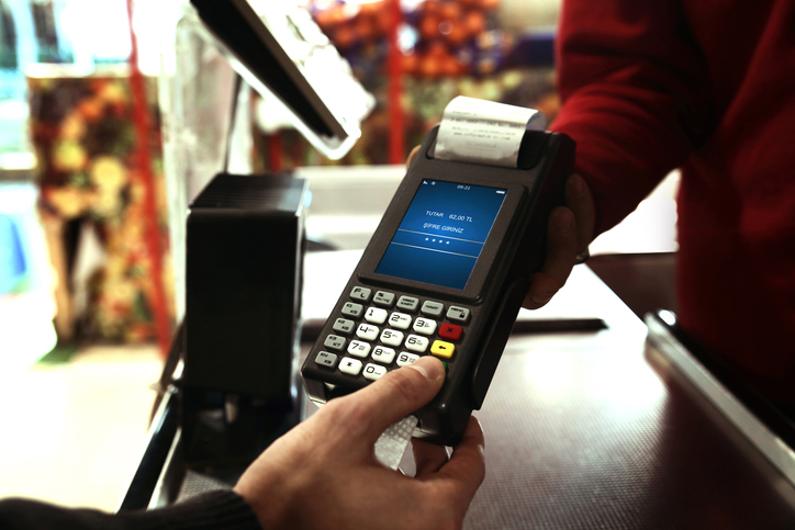 Point-of-sale handheld device being used in an outdoor market.