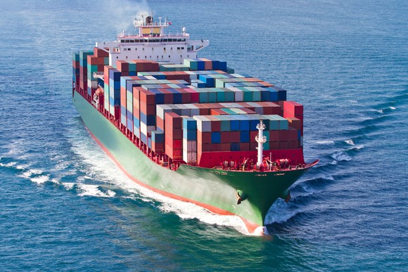 A container ship with a deck stacked full of shipping containers at sea
