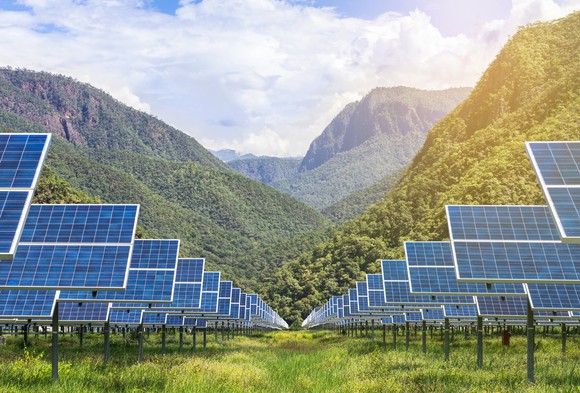 Solar farm with mountains in the background.