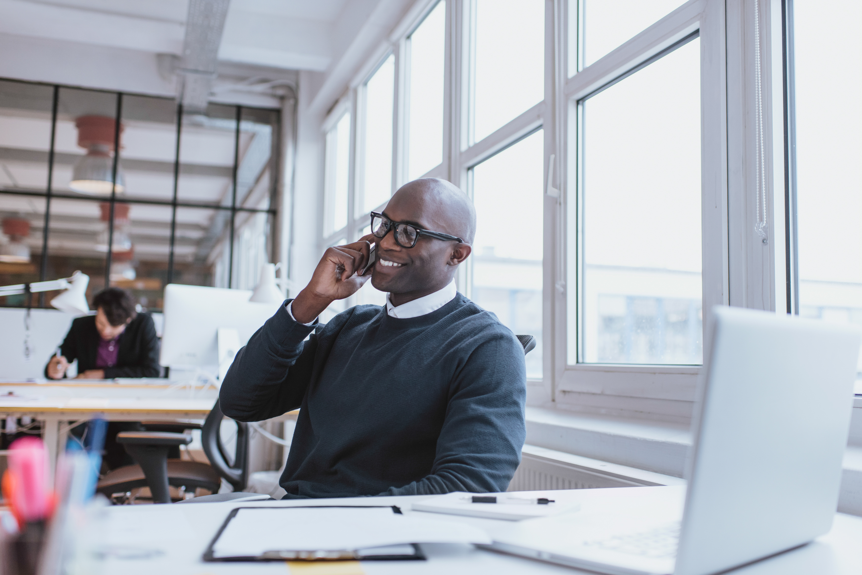 Man sitting at a desk and talking on the phone