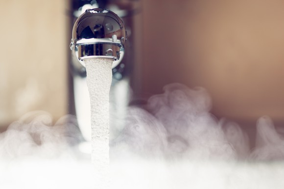Faucet dispensing hot water with steam rising up