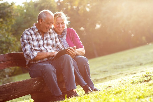 Senior couple using a tablet outdoors